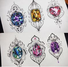 four different colored jewels in ornate designs on white paper, one with an intricate design and the other with diamonds