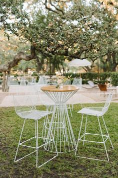 an outdoor table and chairs set up in the grass