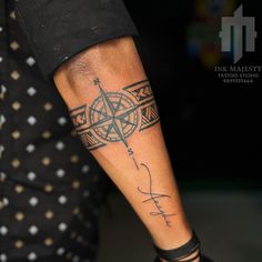 a man with a compass tattoo on his arm