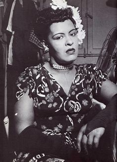 a black and white photo of a woman in a dress with flowers on her head