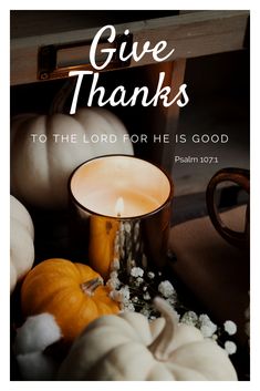 a candle surrounded by pumpkins and cotton balls with the words give thanks to the lord for he is good