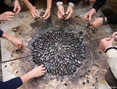 a group of people holding their hands together in a circle on top of a table