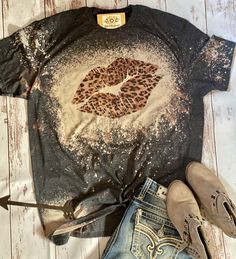 a t - shirt with a leopard print on it and some shoes next to it