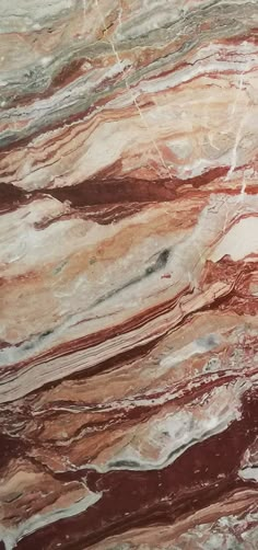 a marble counter top with red and white colors on it's surface, showing the veining