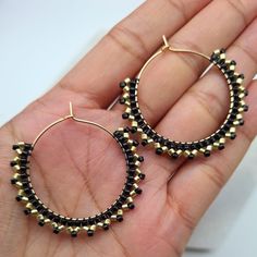 Elegant and unique dangle earrings in gold and black colours. Gold and black handwoven Miyuki beads on a gold plated hoop.  These can also be made in silver instead of gold, choose the option in the drop down menu.  The size of each hoop is approx. 3.8cm All jewellery comes gift wrapped and in black velvet drawstring bags, whether it is for a loved one or a treat for yourself. If you would like to include a hand written message just include a note in your order. Jewellery will be posted with tracking the next business day after placing order. Please note colours may vary slightly due to viewing device or monitor. *CARE TIPS* Take your jewellery off if you are involved in any activity which could scratch, knock or damage it. If in any doubt, take it off and keep it safe. Keep it well away f Handmade Black Brass Jewelry, Handmade Black Hoop Jewelry, Minimalist Handmade Black Hoop Earrings, Black Minimalist Handmade Hoop Earrings, Adjustable Black Beaded Hoop Jewelry, Handmade Black Dangle Hoop Earrings, Black Brass Hoop Earrings As Gift, Small Black Hoop Earrings For Jewelry Making, Adjustable Hoop Earrings With Black Beads As A Gift