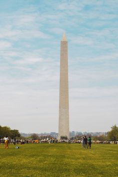 the washington monument in washington dc with people standing around it