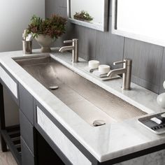 two sinks in a bathroom with mirrors above them