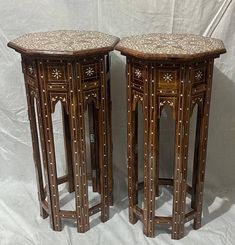 two wooden side tables sitting next to each other on a white sheet covered flooring