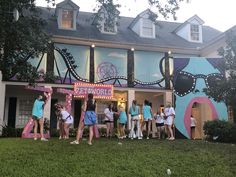 a group of people standing in front of a building that has a carnival sign on it