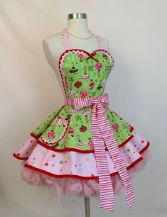 a mannequin wearing a green apron with pink and white polka dots on it