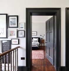 the hallway is decorated in black and white with pictures hanging on the wall above it