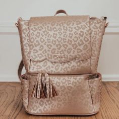 a gold leopard print backpack with tassels on the front and side pockets open