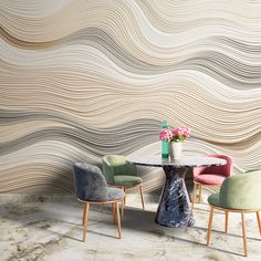 three chairs and a table in front of a wall with wavy designs on it,