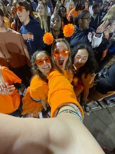 several girls in orange shirts and sun glasses posing for the camera