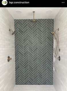 a bathroom with gray and white tile on the walls, shower head, and hand held shower heads