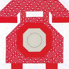 a red and white quilted house with hearts on the front, surrounded by polka dots