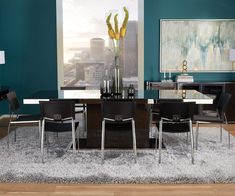 a dining room table with chairs and a rug on the floor in front of it