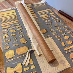 a wooden rolling pin laying on top of a table next to some cut out shapes