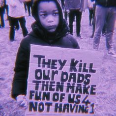 a child holding a sign that says they kill our dads then make fun of us not having