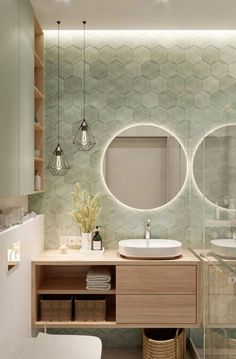 a bathroom with two round mirrors above the sink and lights on the wall behind it