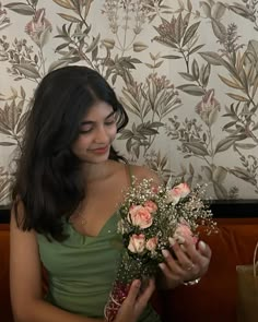 a woman sitting on a couch holding a bouquet of flowers