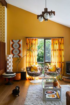 a living room with yellow curtains and furniture