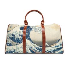 Introducing our stunning Great Wave travel bag, a stylish and durable companion for all your adventures. Made with high-grade waterproof fabric, this personalized travel bag is designed to keep your essentials safe and secure no matter where you go. Featuring the iconic Great Wave painting, this travel bag is a true work of art. The all-over print captures the vivid colors and intricate details of the original painting, from the crashing waves to the graceful swirls of the water. With multiple compartments, a resilient carrying handle, and an adjustable shoulder strap, this travel bag is designed for convenience and comfort. The brown PU leather handles and gold-colored zipper add a touch of luxury to the design, while the polyester lining ensures that your belongings stay safe and dry. At Blue Waterproof Rectangular Travel Bag, Blue Waterproof Travel Bag, Rectangular Travel Accessories With Removable Pouch For Overnight Trips, Waterproof Rectangular Luggage For Daily Use, Rectangular Waterproof Luggage For Daily Use, Waterproof Rectangular Travel Accessories, Rectangular Travel Bag With Luggage Sleeve For Outdoor, White Duffle Bag With Luggage Sleeve For Travel, White Rectangular Travel Bag For Overnight Trips