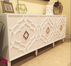 an ornate white cabinet with gold handles and knobs on the doors is displayed in a showroom