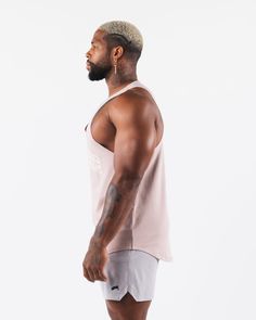 HIGHLIGHTS. Lower chest rounded neckline. Sleeveless cut off style. Sweat-wicking, breathable material. Raw edge finishing on armhole and neckline. Alphalete Stadium logo printed on front. chest. Smooth and stretchy fabric FIT SUGGESTION This item has an oversized fit.. Model is 6'0”/183cm, wearing a size XL with a 47”/119.3cm chest. MATERIALS AND WASHING DIRECTIONS. 94% Cotton, 6% Spandex. We recommend washing inside-out on a cold setting. Hang to dry. Anticipated shrinkage will occur after ini Summer Workout Vest With Dropped Armholes, Summer Training Muscle Tee With Racerback, Summer Racerback Muscle Tee For Training, Breathable Cotton Sleeveless Tank Top, Breathable Sleeveless Tank Top For Light Exercise, Summer Muscle Tee With Scoop Neck For Workout, Scoop Neck Muscle Tee For Summer Workout, Summer Workout Muscle Tee With Scoop Neck, Pink Sleeveless Tank Top For Workout