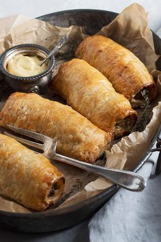 some food is sitting in a pan on a table with silverware and dipping sauce