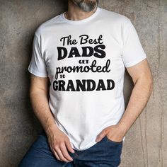 Celebrate the special promotion from Dad to Grandad with our "Best Dads Get Promoted to Grandads" T-Shirt! This heartfelt and stylish tee is perfect for the proud grandad who deserves to be celebrated every day. Made from premium quality fabric, it offers comfort and durability, making it a wonderful gift for birthdays, holidays, or just because. Product Features: Premium Quality Material: Crafted from soft, breathable cotton for all-day comfort. Unique Design: Features a heartwarming "Best Dads White T-shirt With Name Print For Anniversary, Crew Neck T-shirt With Lettering For Gift, Father's Day T-shirt With Lettering And Short Sleeves, Father's Day White T-shirt With Logo Print, Father's Day T-shirt With Lettering, Father's Day White T-shirt With Logo, Father's Day White Slogan T-shirt, Father's Day Anniversary Graphic Print Tops, White Text Print Top For Anniversary