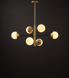 a chandelier with five lights hanging from it's sides and four balls on each side