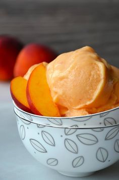 a bowl filled with ice cream and sliced peaches