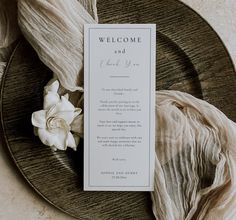 a wedding welcome card on a plate with flowers