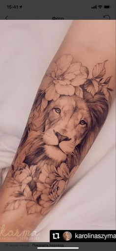 a lion and flowers tattoo on the arm