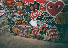 a laptop covered in stickers sitting on top of a table