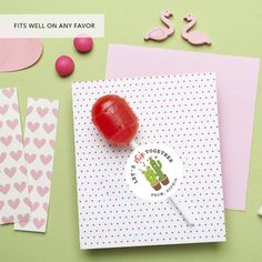 a candy lollipop sitting on top of a card next to some other items