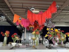 the table is set with silverware and flowers in vases, candles, and streamers