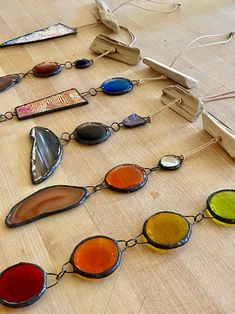 a group of stained glass pieces on a wooden table next to an empty piece of wood