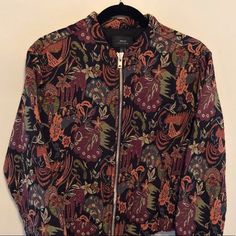 This Never Worn Multi Colored Bomber Jacket Is In Mint Condition. It Is Embroidered From Top To Bottom With A Flower Pattern And Has Two Side Pockets. Length Is 21” And Width (Shoulder To Shoulder) Is 18”. Made From 62% Cotton And 38% Polyester. Fall Outerwear With Multicolor Embroidery And Floral Print, Fall Floral Print Outerwear With Multicolor Embroidery, Fall Multicolor Embroidered Floral Outerwear, Fall Floral Print Multicolor Embroidered Outerwear, Fall Printed Cotton Outerwear, Printed Cotton Fall Outerwear, Printed Cotton Outerwear For Fall, Spring Floral Print Patterned Outerwear, Casual Outerwear With Multicolor Floral Embroidery