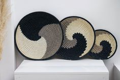 three black and white baskets sitting on top of a shelf