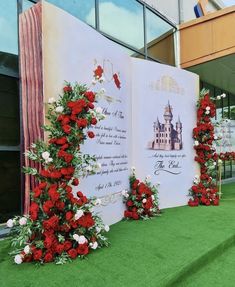 red and white flowers are on display in front of a large sheet of paper with an image of a castle