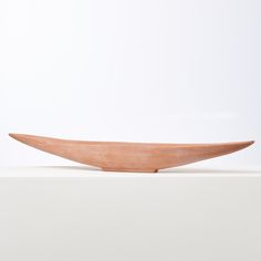 a wooden bowl sitting on top of a white surface