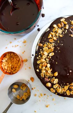 a chocolate cake with nuts on top and spoons next to it