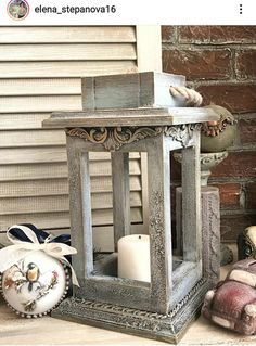 an old fashioned lantern is sitting on the ground next to stuffed animals and other items