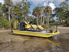 a yellow boat sitting on top of a body of water next to some palm trees