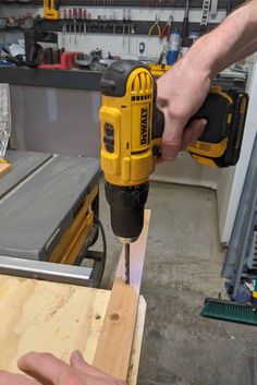 a person using a drill to cut wood