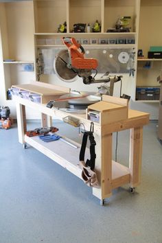 a workbench in a garage with tools on the table and shelves behind it