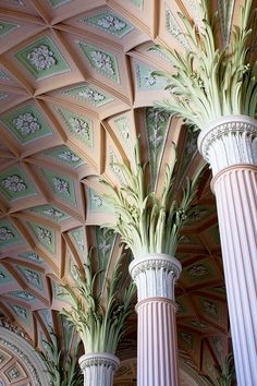 three tall white vases with green plants on them in a room that looks like a ceiling