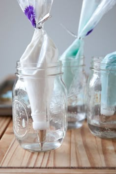 three mason jars with toothbrushes in them